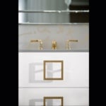 White bathroom vanity with gold handles and faucet