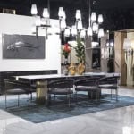 Marble dining table with metal base and upholstered chairs in showroom