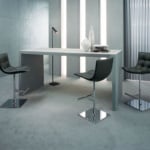 Leather bar stools with chrome bases around a gray table