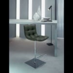 Leather bar stool with chrome metal base beside desk