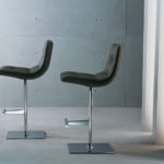 Two leather and chrome bar stools on a gray floor