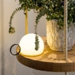 Polyethylene table lamp with circular handle on wooden surface