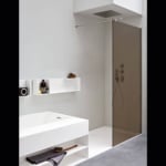 Glass shower enclosure with metal fixtures in a bathroom setting
