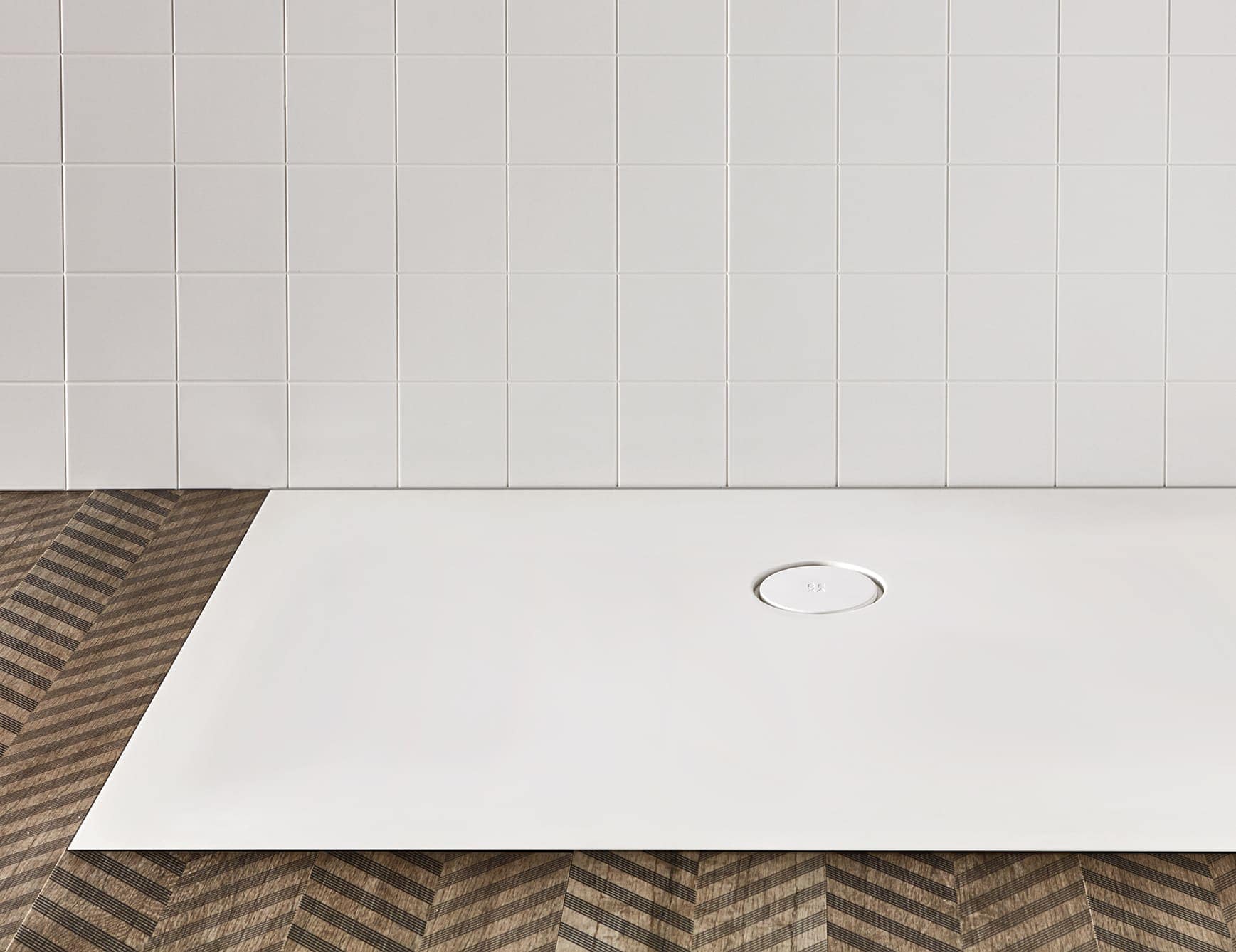 Rectangular resin shower tray with central drain on patterned floor