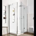 Glass shower enclosure with metal frame in tiled bathroom