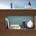 Wood bathroom vanity cabinet with open shelf and countertop accessories