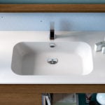 Wood bathroom vanity cabinet with integrated rectangular sink and chrome faucet