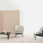 Leather lounge chair with curved backrest and metal legs in a living room setting