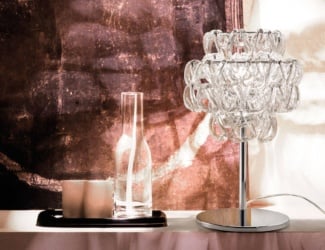 Diadema table lamp shown in crystal glass. Structure composed in glossy chrome. This collection combines cutting edge designs by leading international designers with the secrets of the traditional craft of glass blowing. Metallic finish also available in matt bronze. Available in a chandelier and floor lamp version. Made in Italy.