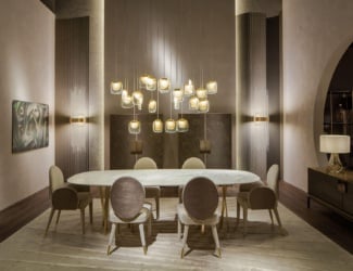 Cooper luxury Italian designer dining table shown in White Onyx top with brushed gold metal legs, partially covered in tan leather. Marble top options: Black Marquinia, Black and Gold, Emperador Dark, Travertino Navona, Bianco Carrara, Bamboo, Statuario Venato, Silk Georgette Blue, Sahara Noir and Versylis. Veneered wood top options: Eucalyptus Frisé, Grey Carbalho, Rose Carbalho and Oak Veneered dyed Wengé. Agate top options: Grey, Green and Black. Metal leg options: Brushed Bronze, Brushed Dark Bronze and Brushed Gold. Optional base covering in leather. Also shown in Emperador Dark. This luxury modern furniture collection features a chic and adaptive style to any living space. Available in five different dimensions. Available in coffee table version. Made in Italy.