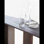 Wood console table with ebony finish and glass vases on top
