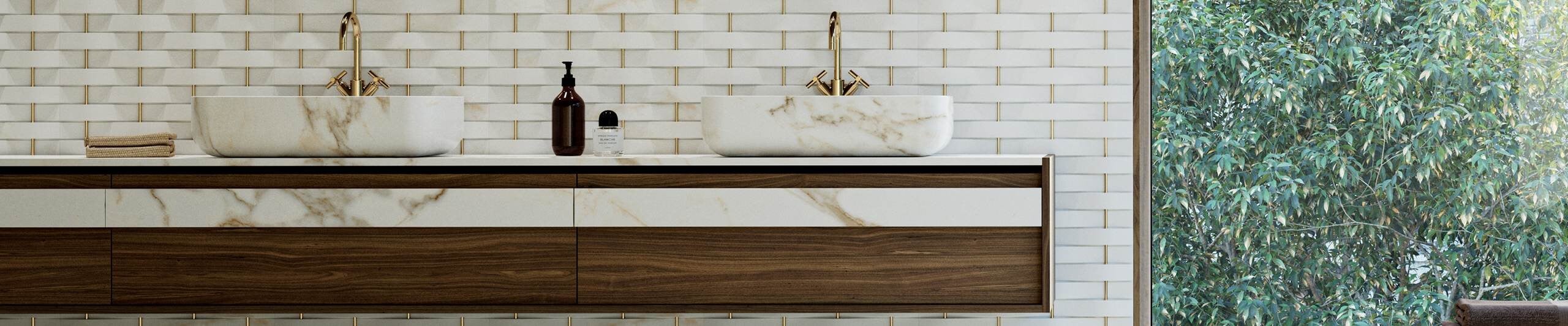 Double marble sinks on wooden bathroom vanity with brass faucets