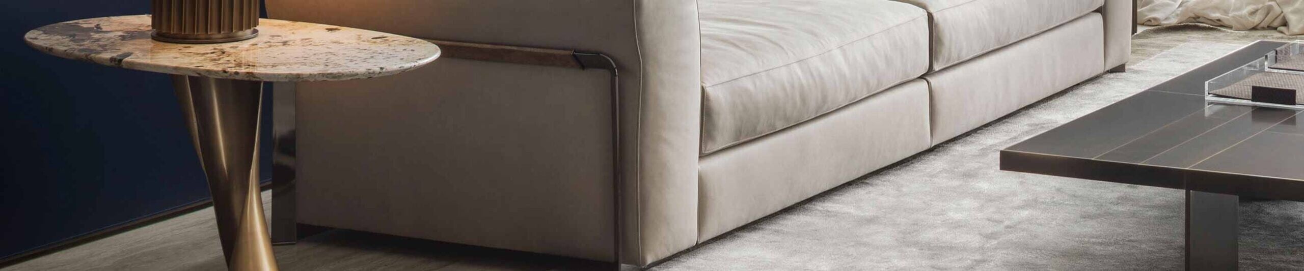 Beige fabric sofa beside round marble side table and metal coffee table