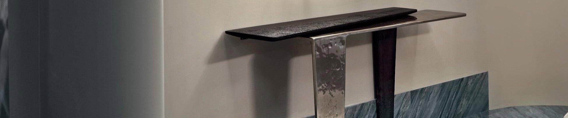 Metal and wood console table with polished finish against wall