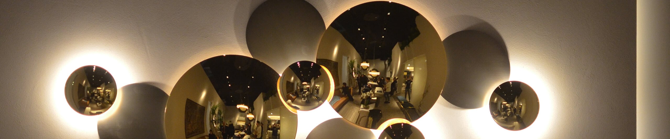 Wall light fixture with circular metallic discs and reflective finish