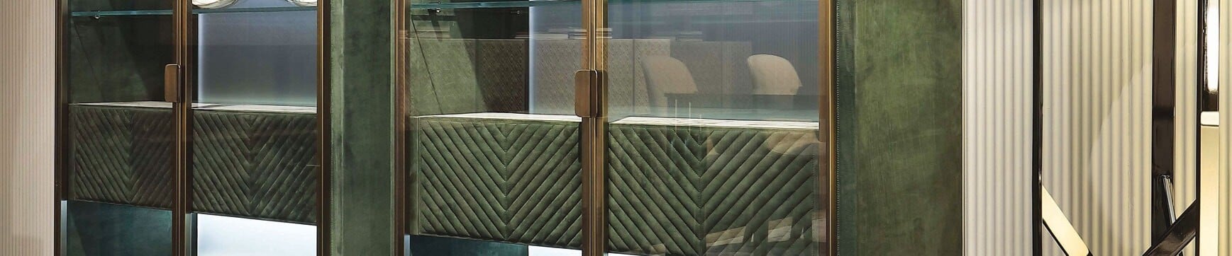 Glass and metal storage cabinet with green upholstered panels
