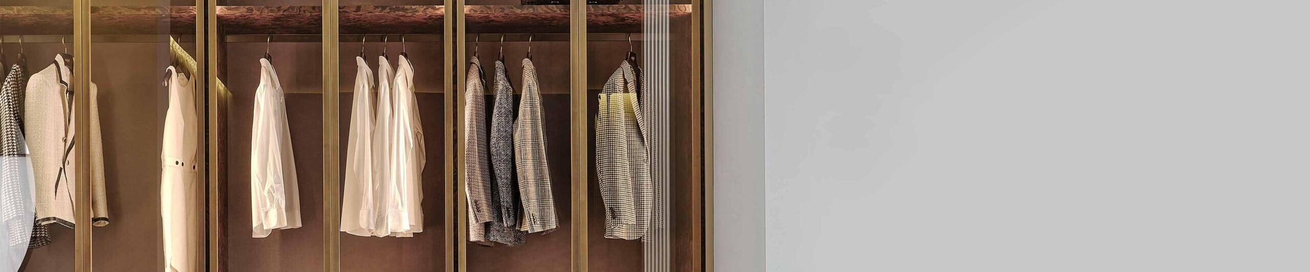 Wood wardrobe with glass doors and hanging clothes