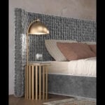 Upholstered bed with textured gray velvet headboard beside metal table and lamp