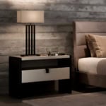 Wood bedside table with two drawers beside a bed