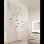Glass bathroom vanity cabinet with marble pattern and brass knobs.