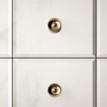 Glass bathroom vanity cabinet with metallic knobs