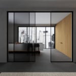 Glass architectural sliding doors with black metal frame in interior setting
