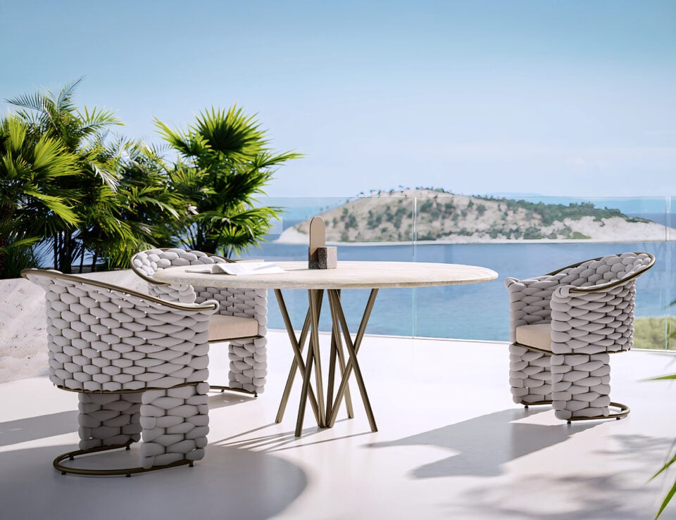 Fabric outdoor dining chairs with woven design around round table on terrace