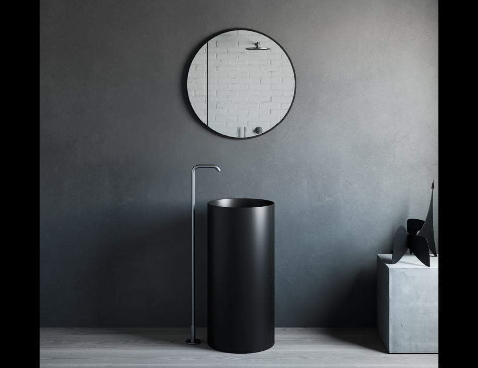 Freestanding cylindrical resin washbasin in a bathroom.
