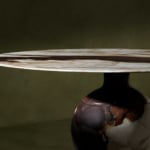 Round marble dining table with brown veining.