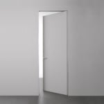 Minimalist gray open door in white wall.