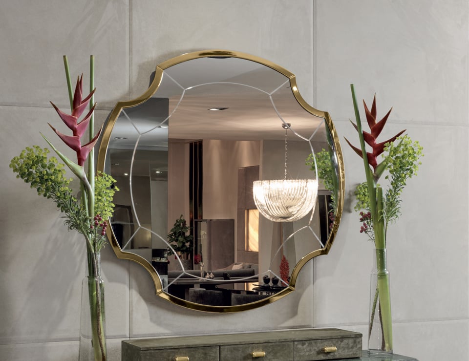 Elegant mirror with floral arrangements.
