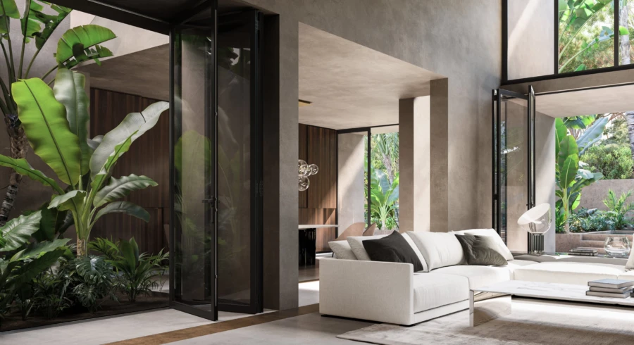 Pivoting glass doors opening a living room onto tropical planting and a concrete terrace.